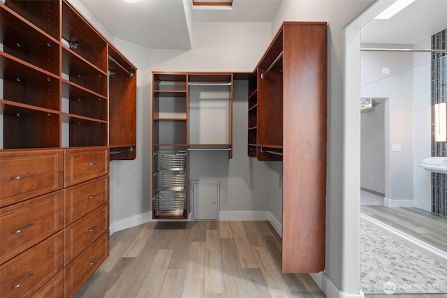 walk in closet with wood finished floors