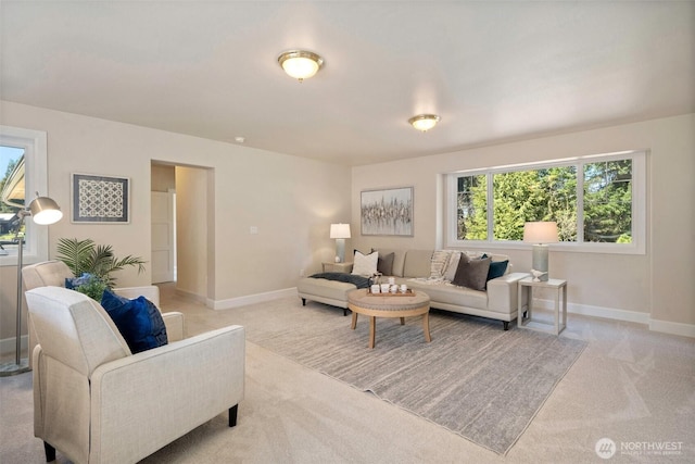living area with baseboards and light carpet