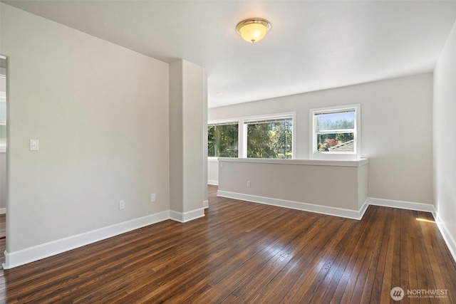 spare room with dark wood finished floors and baseboards