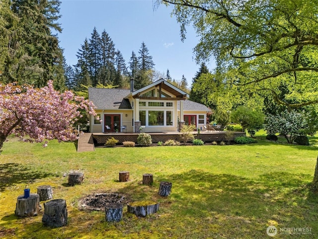 back of house featuring a lawn and a deck