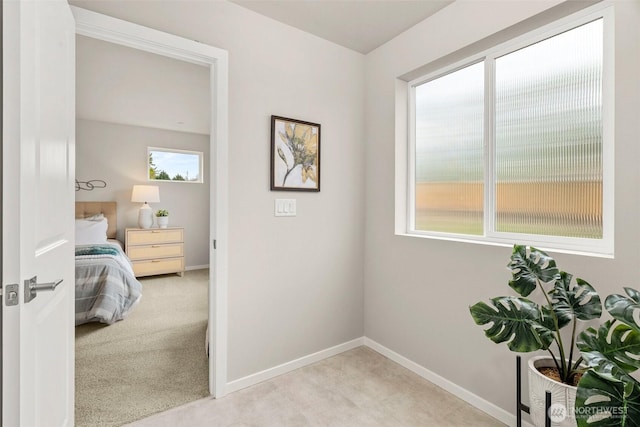 hallway featuring carpet flooring and baseboards