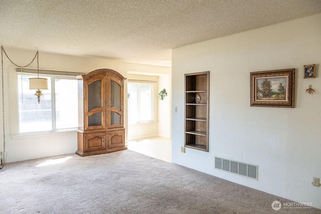 609 W Whitman Dr, College Place, WA 99324 - unfurnished living room with carpet floors, a textured ceiling, and built in shelves