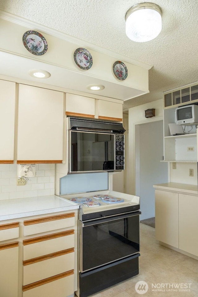 609 W Whitman Dr, College Place, WA 99324 - kitchen with black appliances, a textured ceiling, light countertops, decorative backsplash, and crown molding