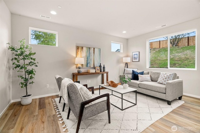 living area with baseboards, plenty of natural light, and visible vents