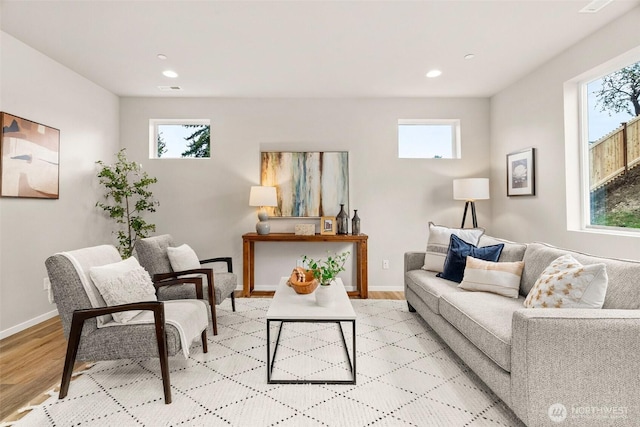 living area with recessed lighting, light wood finished floors, baseboards, and a healthy amount of sunlight