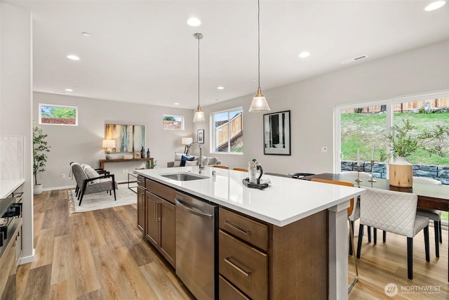 kitchen with recessed lighting, light wood-type flooring, a sink, and dishwasher