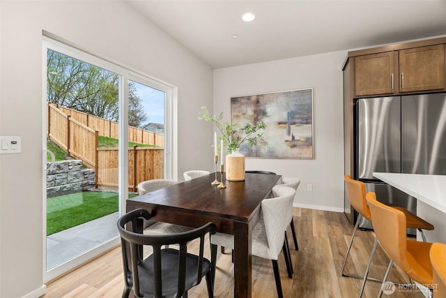 dining room featuring recessed lighting, light wood-style flooring, baseboards, and stairway