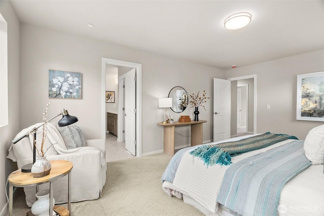 carpeted bedroom featuring connected bathroom and baseboards