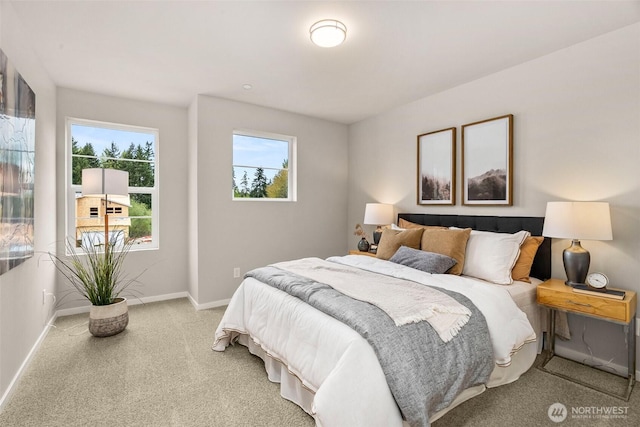 bedroom featuring light colored carpet and baseboards
