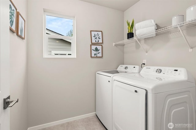 washroom featuring washer and dryer, laundry area, and baseboards