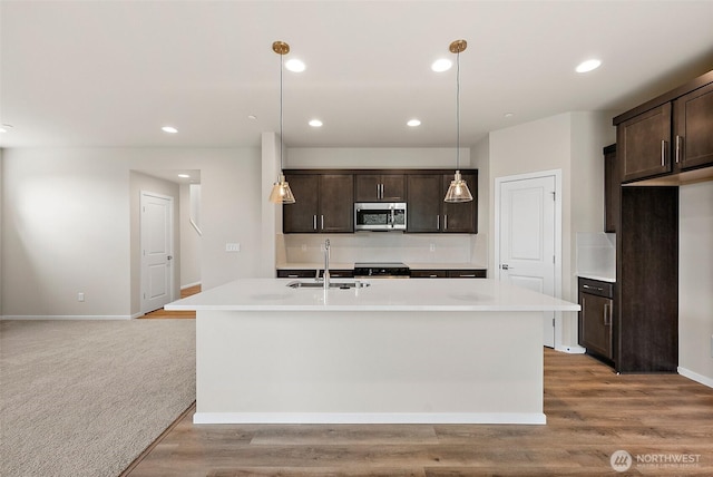 19504 15th Ave E, Spanaway, WA 98387 - kitchen featuring stainless steel microwave, dark brown cabinetry, stove, light countertops, and recessed lighting