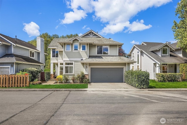 craftsman-style home with a garage, driveway, and fence
