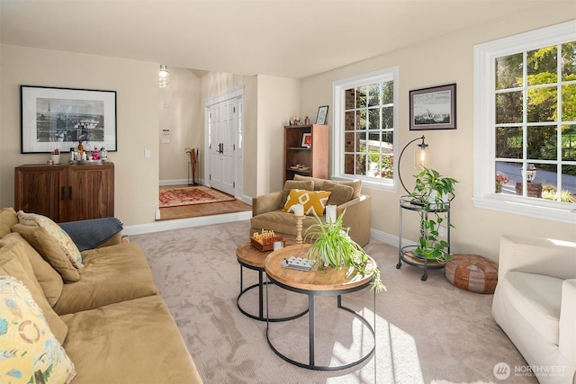 living room featuring baseboards and light carpet
