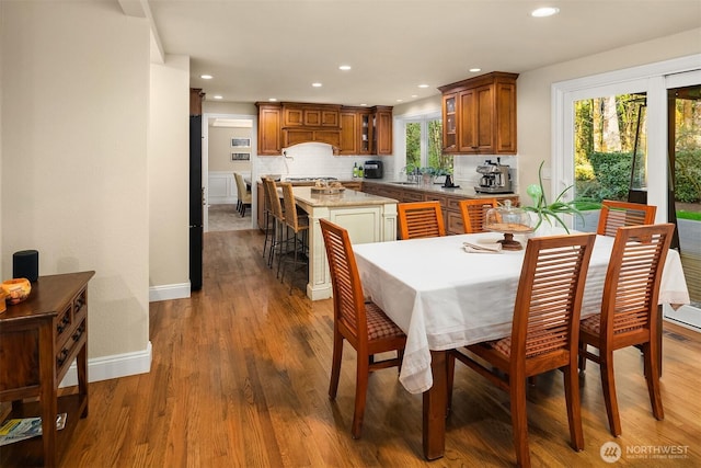 dining room with a healthy amount of sunlight, baseboards, recessed lighting, and wood finished floors