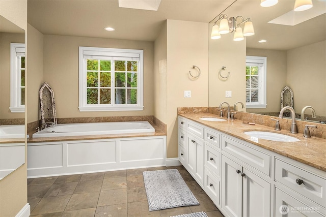full bath with a sink, double vanity, and a bath