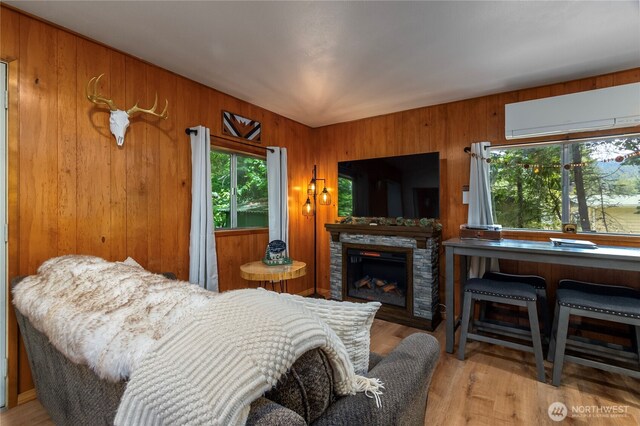 105 Robinwood Pl, Packwood, WA 98361 - bedroom featuring wood finished floors, wood walls, a stone fireplace, and a wall unit AC