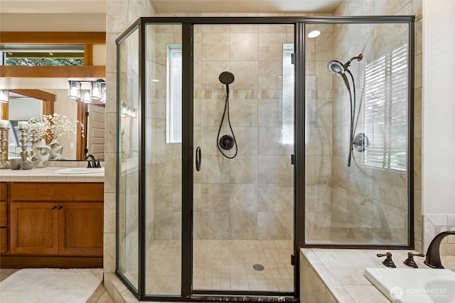 bathroom with a garden tub, a stall shower, and vanity