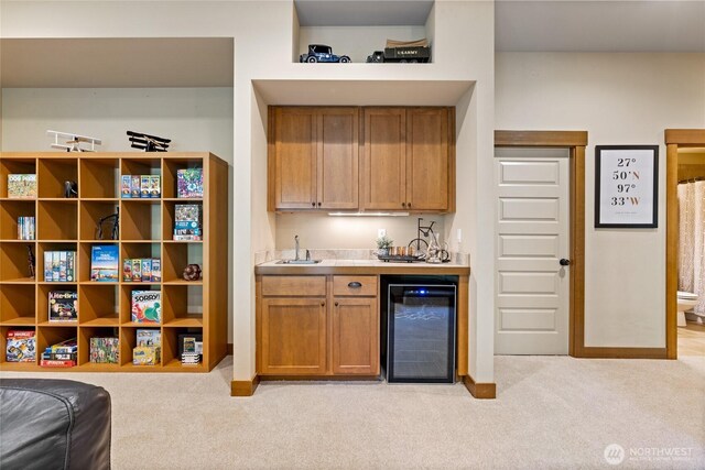 bar featuring wine cooler, light carpet, indoor wet bar, baseboards, and a sink