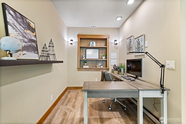 office space featuring baseboards and wood finished floors