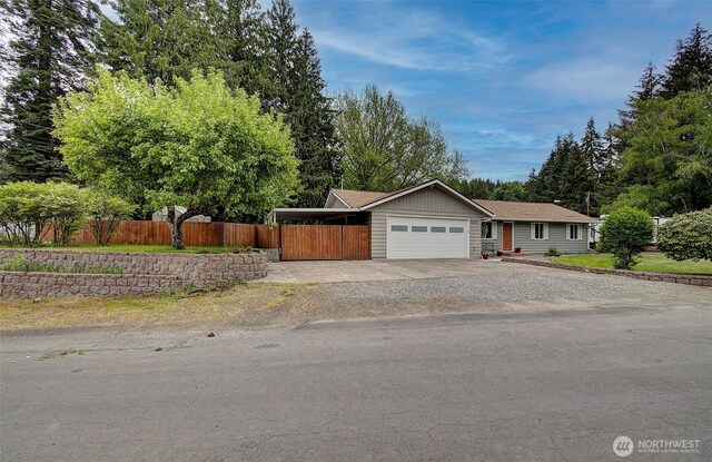 single story home with a garage, fence, and driveway