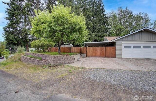 exterior space featuring fence, an attached garage, and driveway