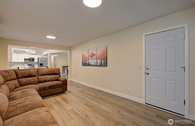 living room featuring baseboards and light wood-style flooring