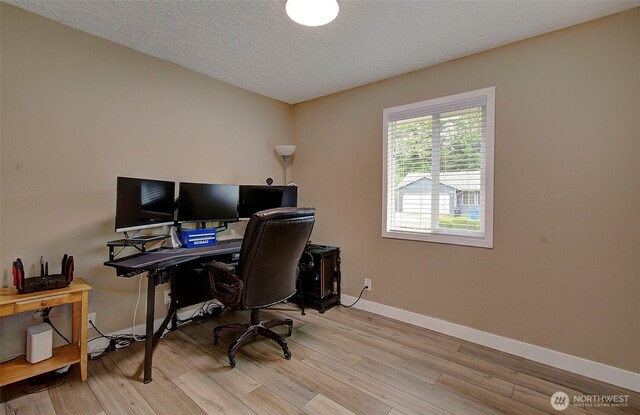 office space featuring a textured ceiling, baseboards, and wood finished floors