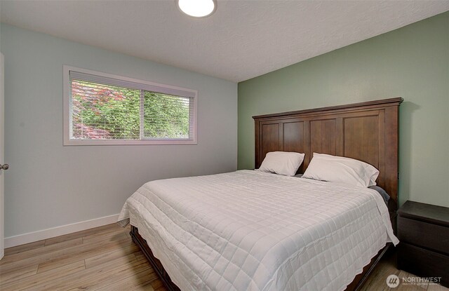bedroom with baseboards and light wood finished floors