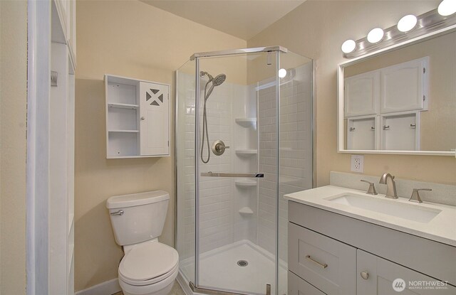 bathroom featuring vanity, baseboards, toilet, and a shower stall
