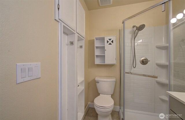 bathroom featuring visible vents, a stall shower, and toilet