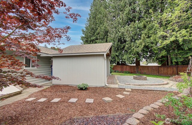 view of yard featuring fence and a fire pit