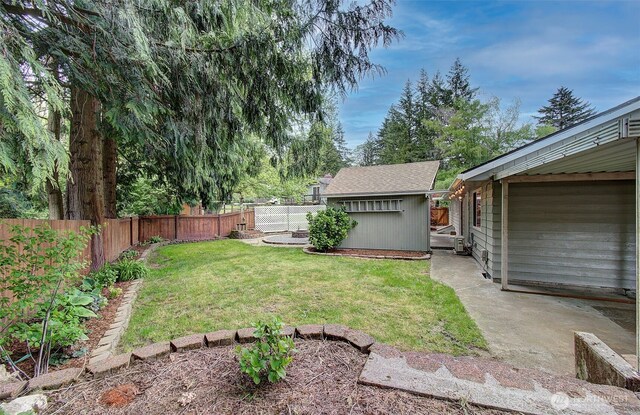 view of yard with a fenced backyard and an outbuilding