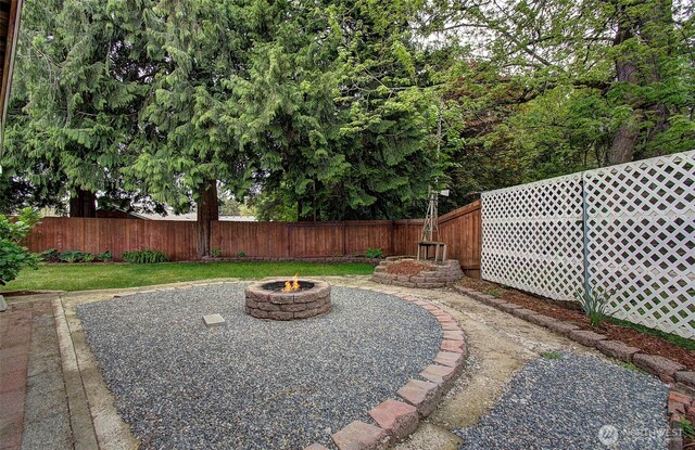view of yard featuring a fenced backyard and an outdoor fire pit