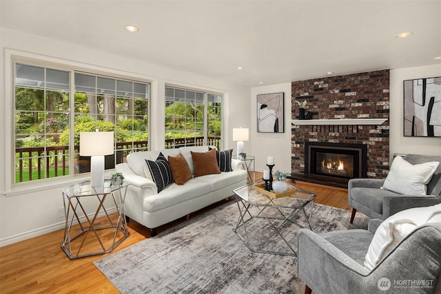 living room with baseboards, wood finished floors, a fireplace, and recessed lighting