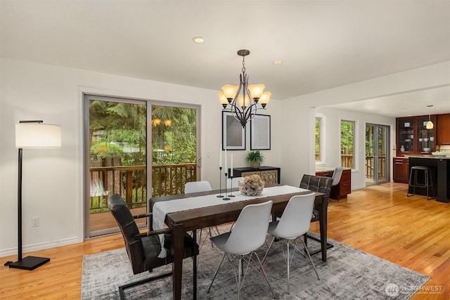 dining area featuring light wood-type flooring, a chandelier, recessed lighting, and baseboards