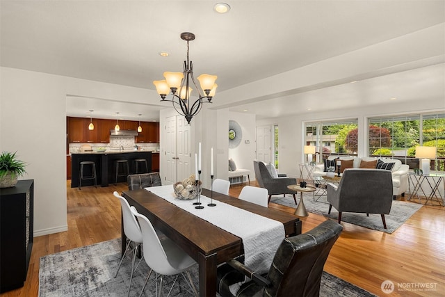dining space featuring light wood finished floors, a chandelier, recessed lighting, and baseboards