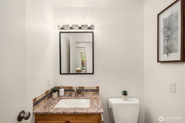 half bathroom featuring vanity and toilet