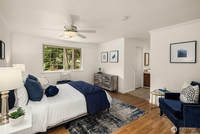 bedroom with ornamental molding, wood finished floors, ensuite bath, and ceiling fan