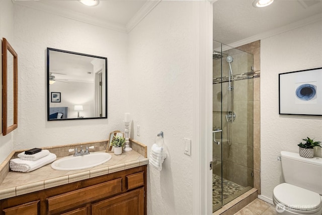 full bath featuring ornamental molding, toilet, a stall shower, vanity, and a ceiling fan