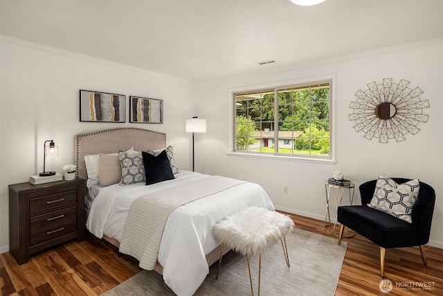 bedroom featuring baseboards, dark wood-type flooring, and ornamental molding