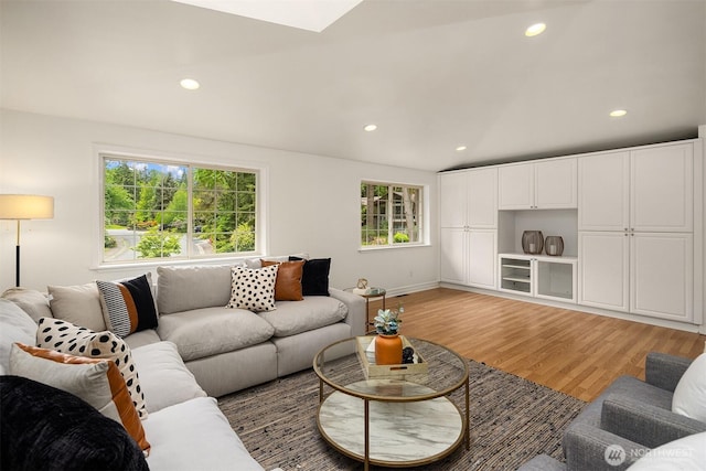 living room with light wood-style flooring, recessed lighting, and baseboards