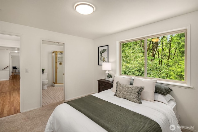 bedroom featuring connected bathroom, carpet floors, and baseboards