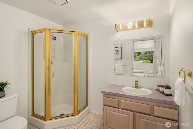full bathroom featuring a stall shower, toilet, tile patterned flooring, vanity, and baseboards
