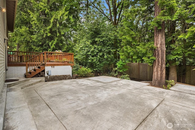 view of patio with a wooden deck, fence, and stairs