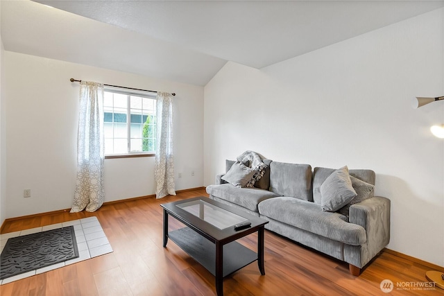 living room with vaulted ceiling, wood finished floors, and baseboards