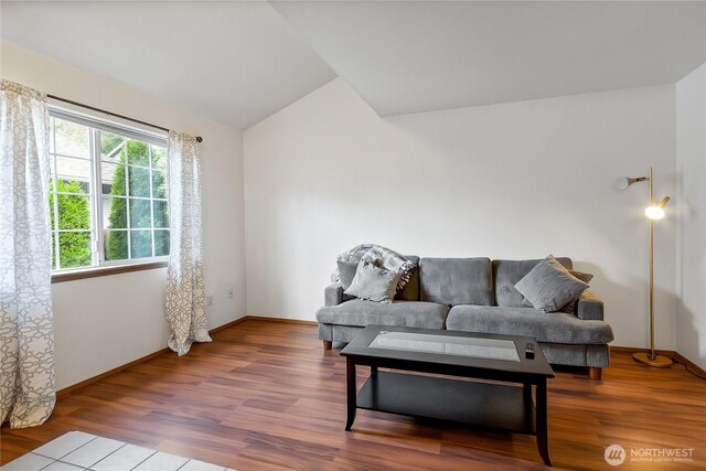 living room with vaulted ceiling, wood finished floors, and baseboards