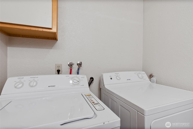 clothes washing area with washer and clothes dryer and laundry area