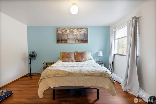 bedroom with baseboards and wood finished floors