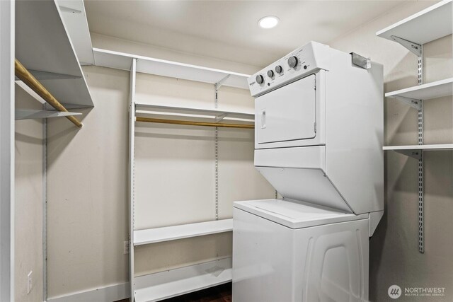 washroom featuring stacked washing maching and dryer, laundry area, and recessed lighting