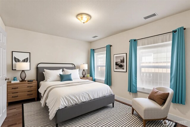 bedroom featuring visible vents, wood finished floors, and baseboards